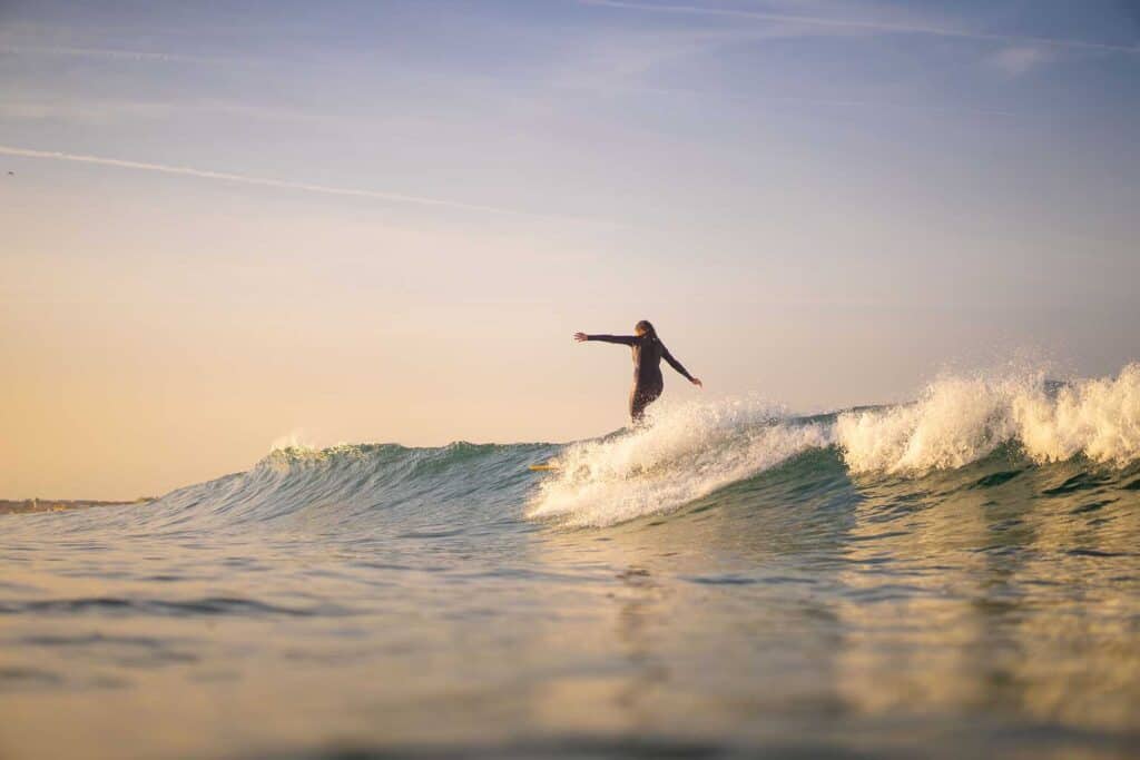 Een vrouw op een surfplank in de branding.