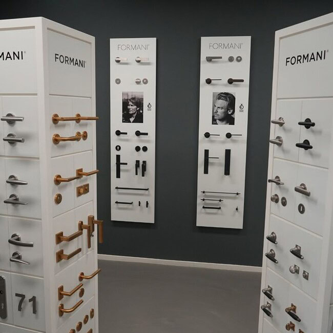 De showroom van online deurbeslagshop met een wand vol met deurklinken ter inspiratie.