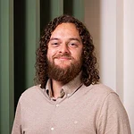 1. Man met lang, curly haar en een lichte baard, professioneel portret voor digitale marketing en consultancydiensten, voor een zakelijk en authentiek imago.