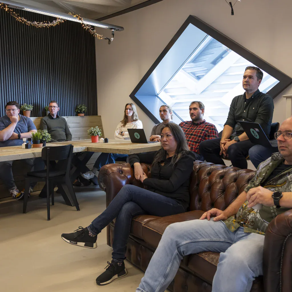 Twee collega's zitten aan tafel tijdens een overleg in de vergaderkamer.