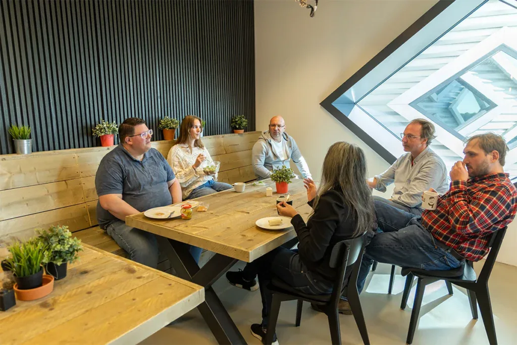 Het team is aan het lunchen in de kantine op kantoor.