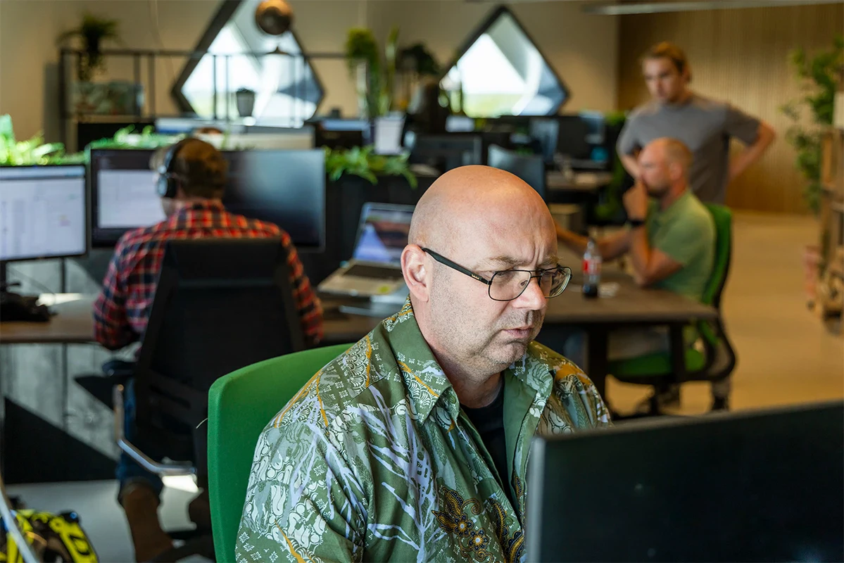 Twee collega's staan en overleggen in een vergaderkamer op kantoor.