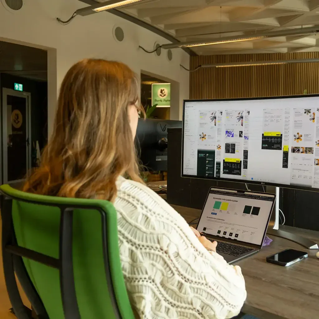Designer achter haar bureau aan het werk op kantoor.