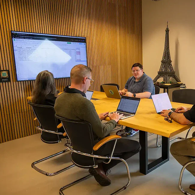 Directie zit aan een tafel en is aan het vergaderen in de boardroom.