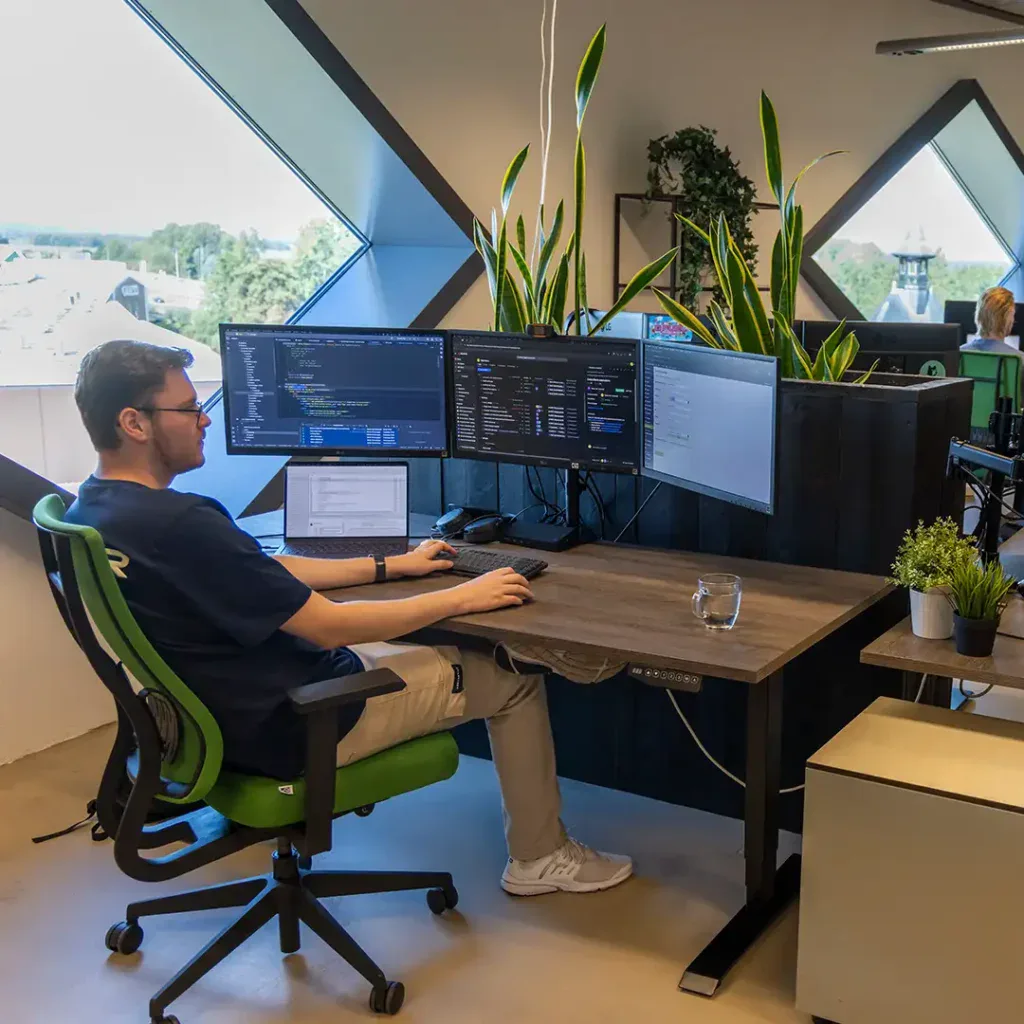 Back end developer is aan het werk achter zijn bureau.