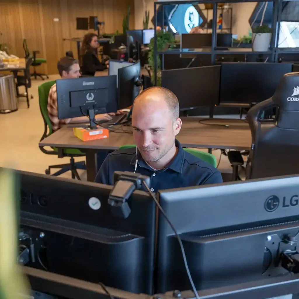 Front end developer. zit achter zijn computer te werken op kantoor.